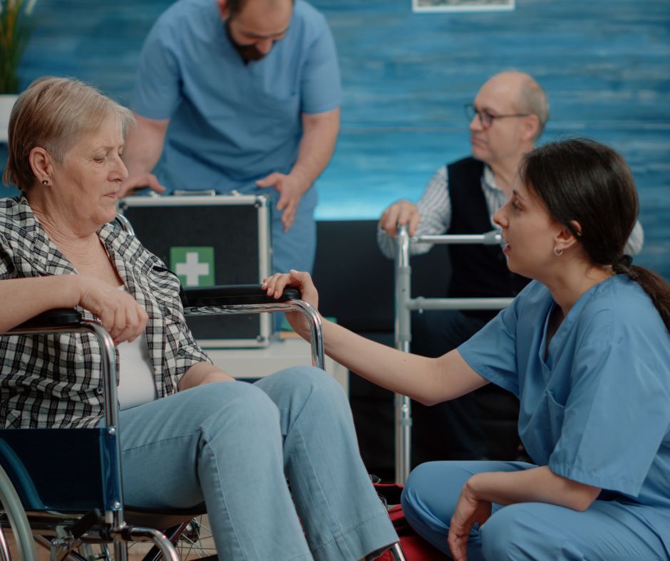 nursing assistant speaking to patient in wheelchair