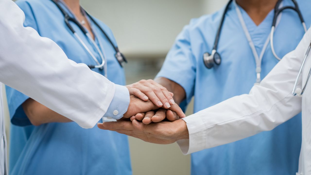 nurses in a group with the hands together