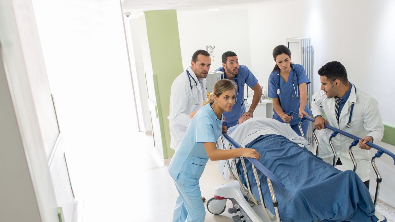 nurses and a doctor with a patient going to ER
