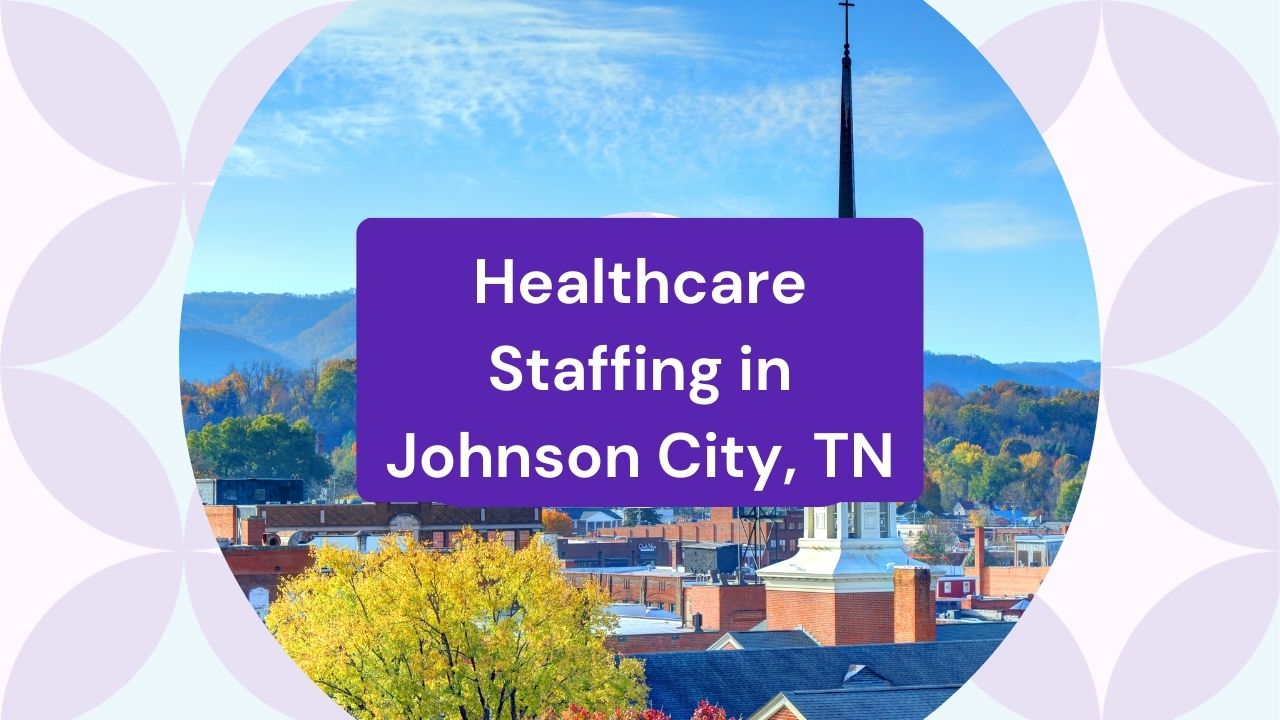 city skyline of Johnson City, with church steeple, colorful trees, and mountains in the background