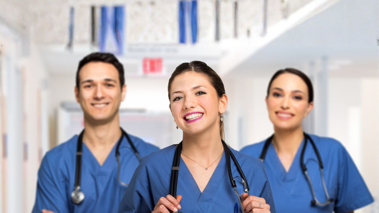 Three nurses with stethoscopes smiling